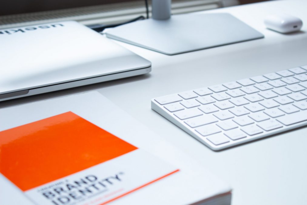 brand identity book on a desk with a keyboard and monitor
