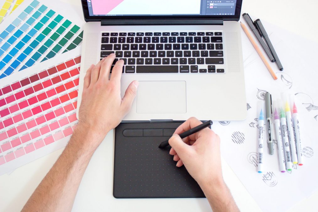 finance stream employee designing a new brand with a mac book and colour palettes