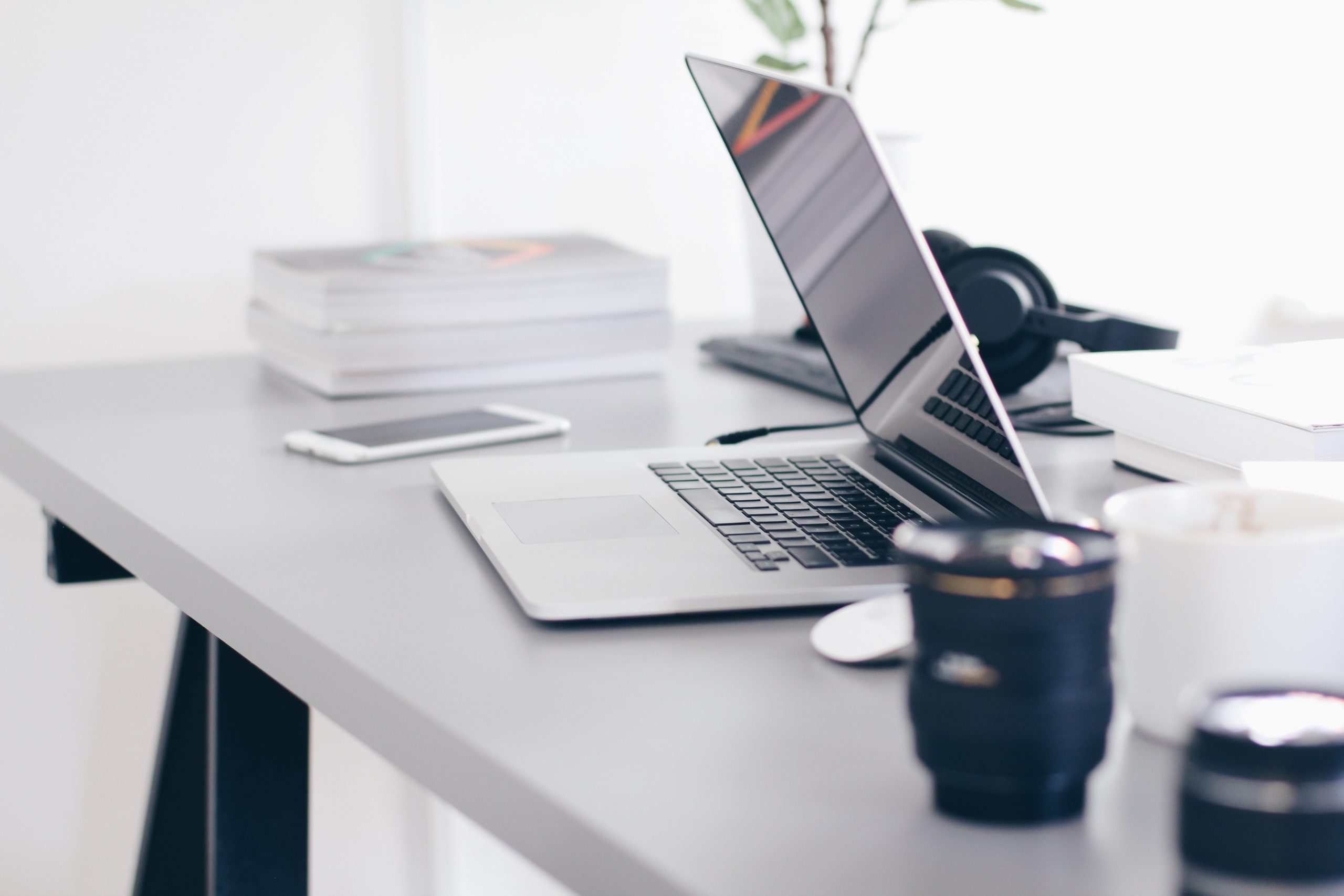 home office set up during the pandemic with mug and headphones and phone