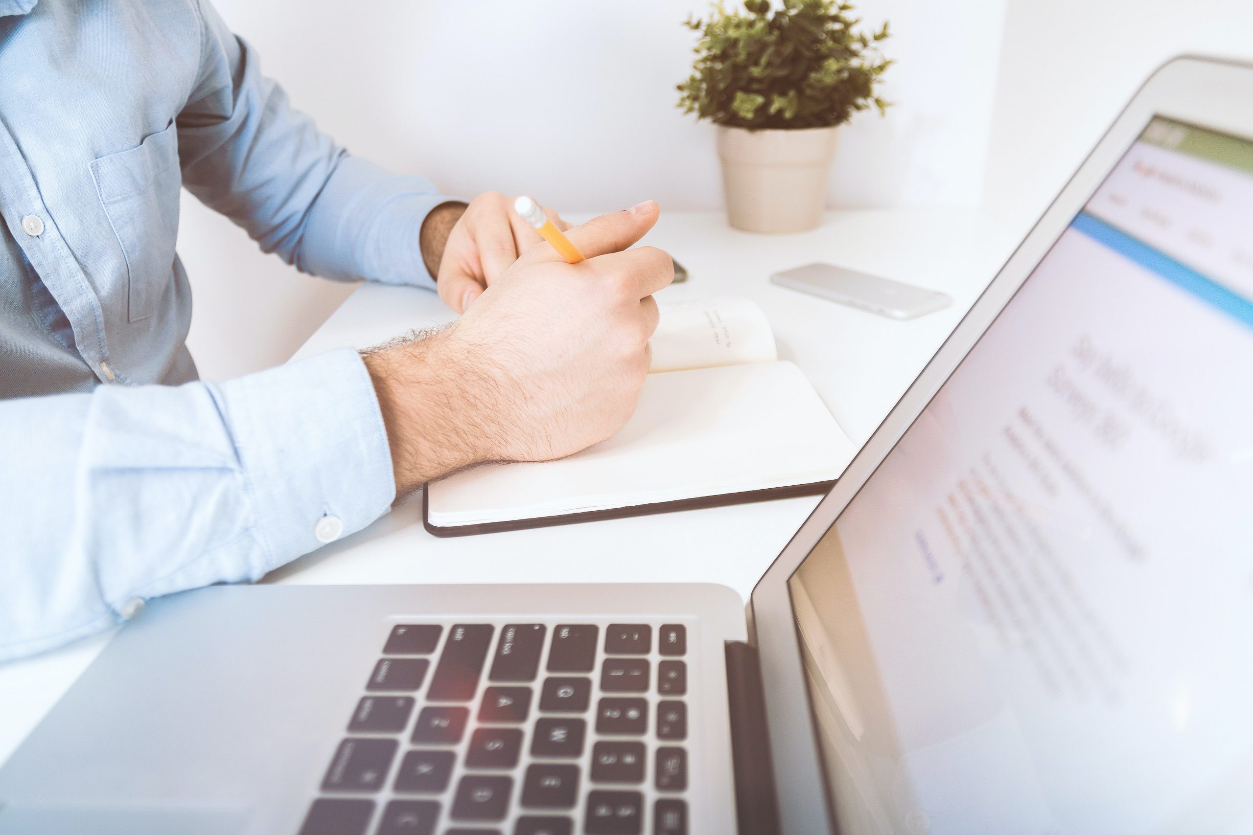 laptop and a hand ready to write and plan an email marketing strategy