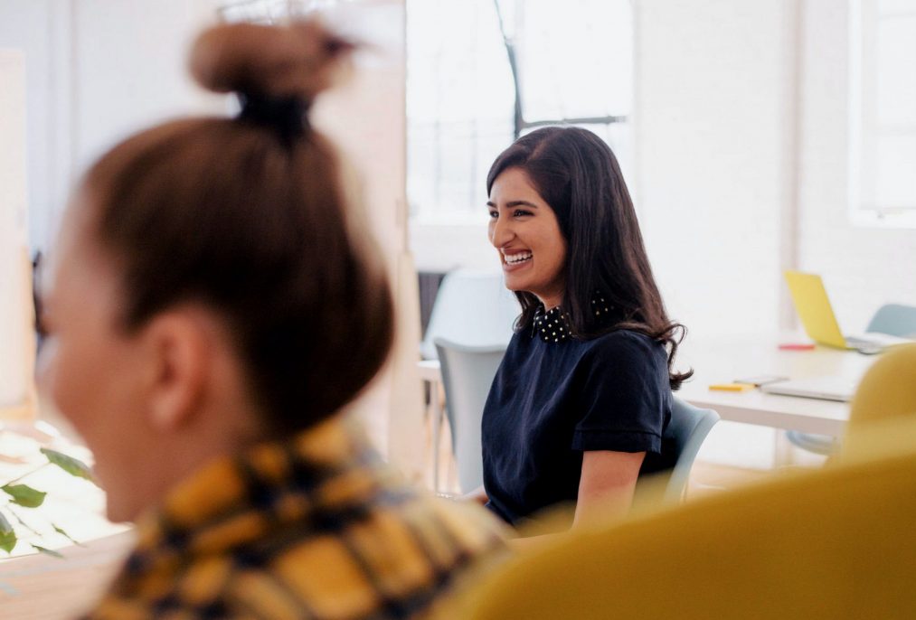 two women laughing in the office