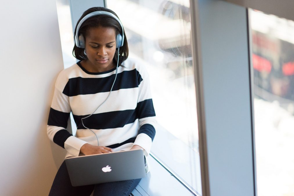 lady watching a video on a website with headphones on